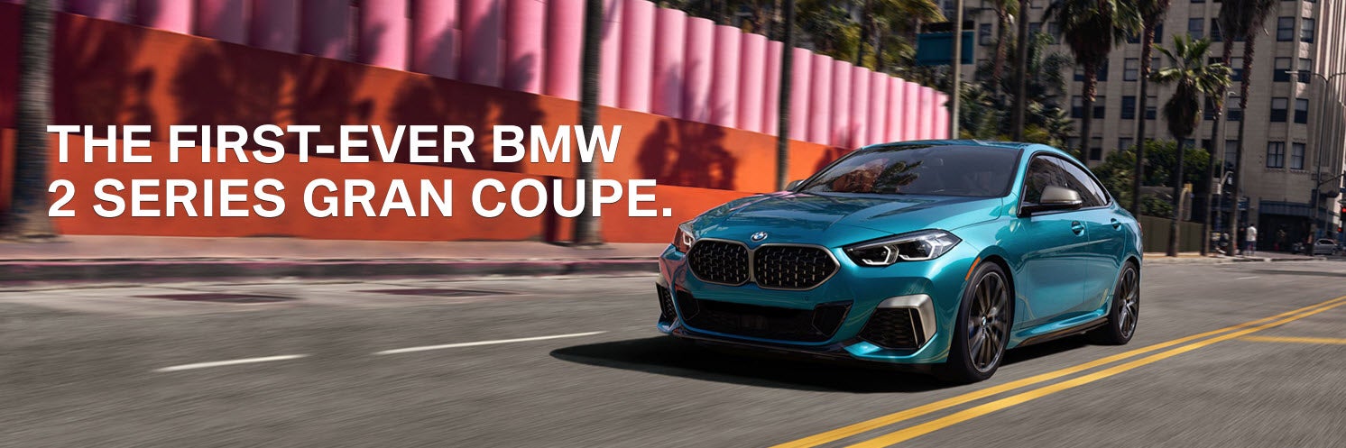 Un BMW Serie 2 Gran Coupé azul metalizado circulando por la calle durante el día.