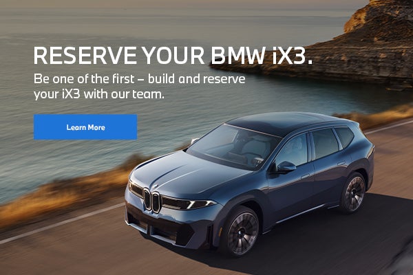 Un BMW iX3 circulando por una carretera cerca de las montañas y el agua.