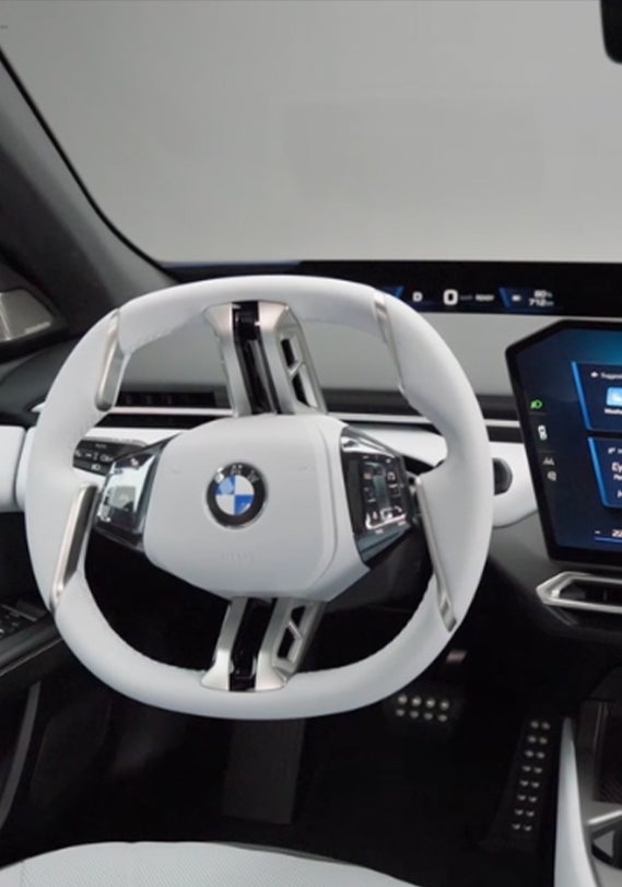 Primer plano de la pantalla central y el volante del BMW i3.