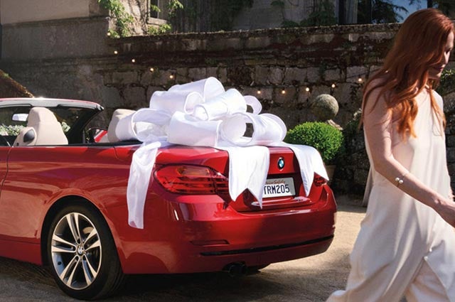 Técnico de servicio de BMW inspeccionando un BMW en un elevador.